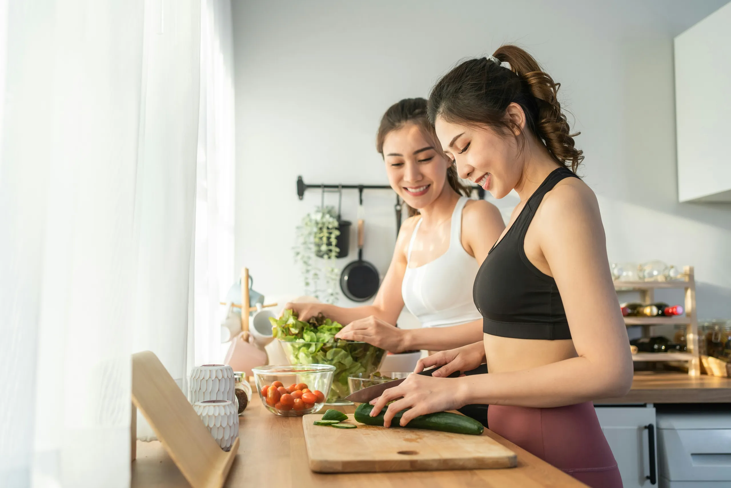 Dos mujeres activas preparan una comida saludable en la cocina